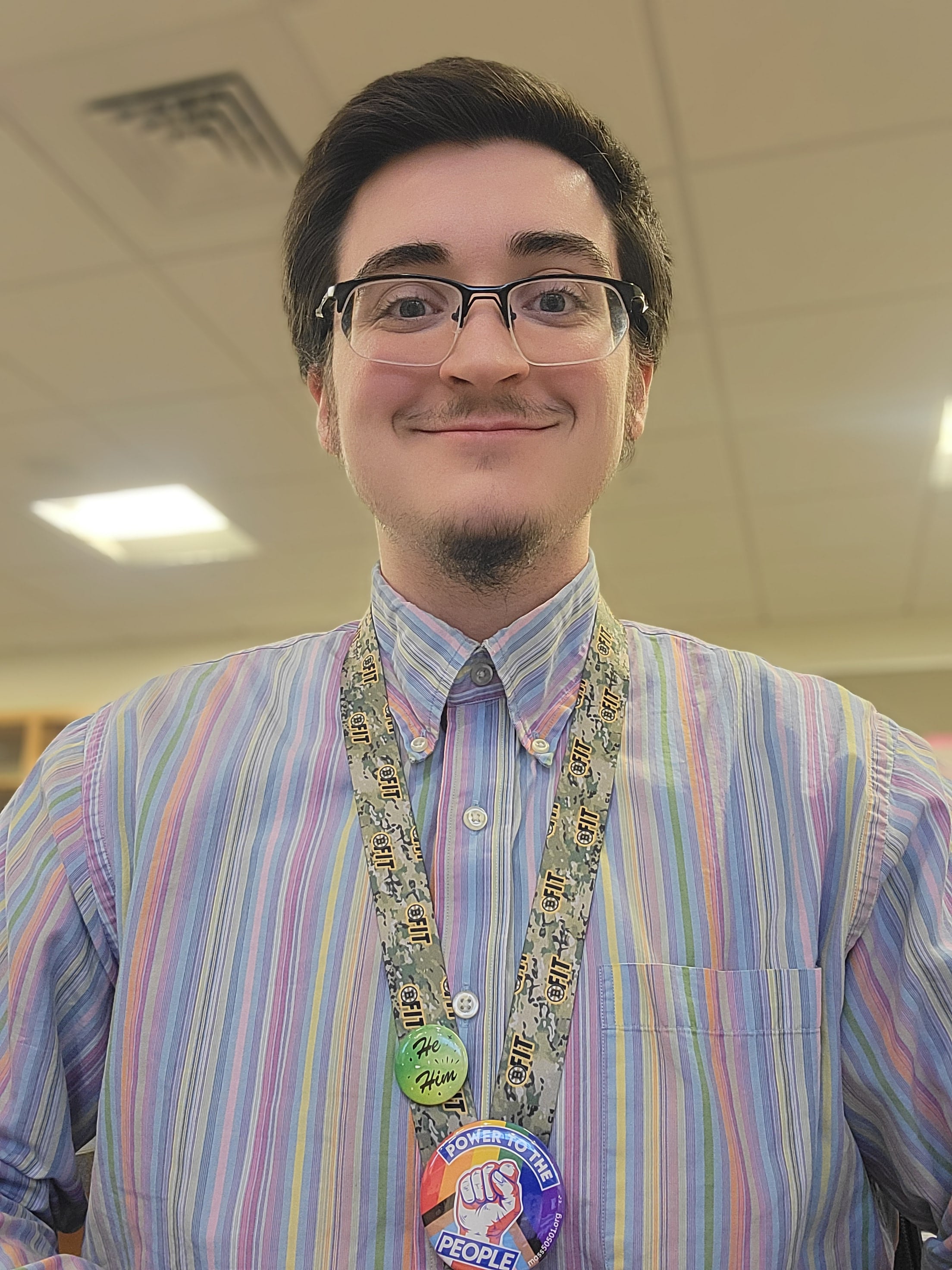 Eben Taylor, a white man with black hair and a small beard smiling.