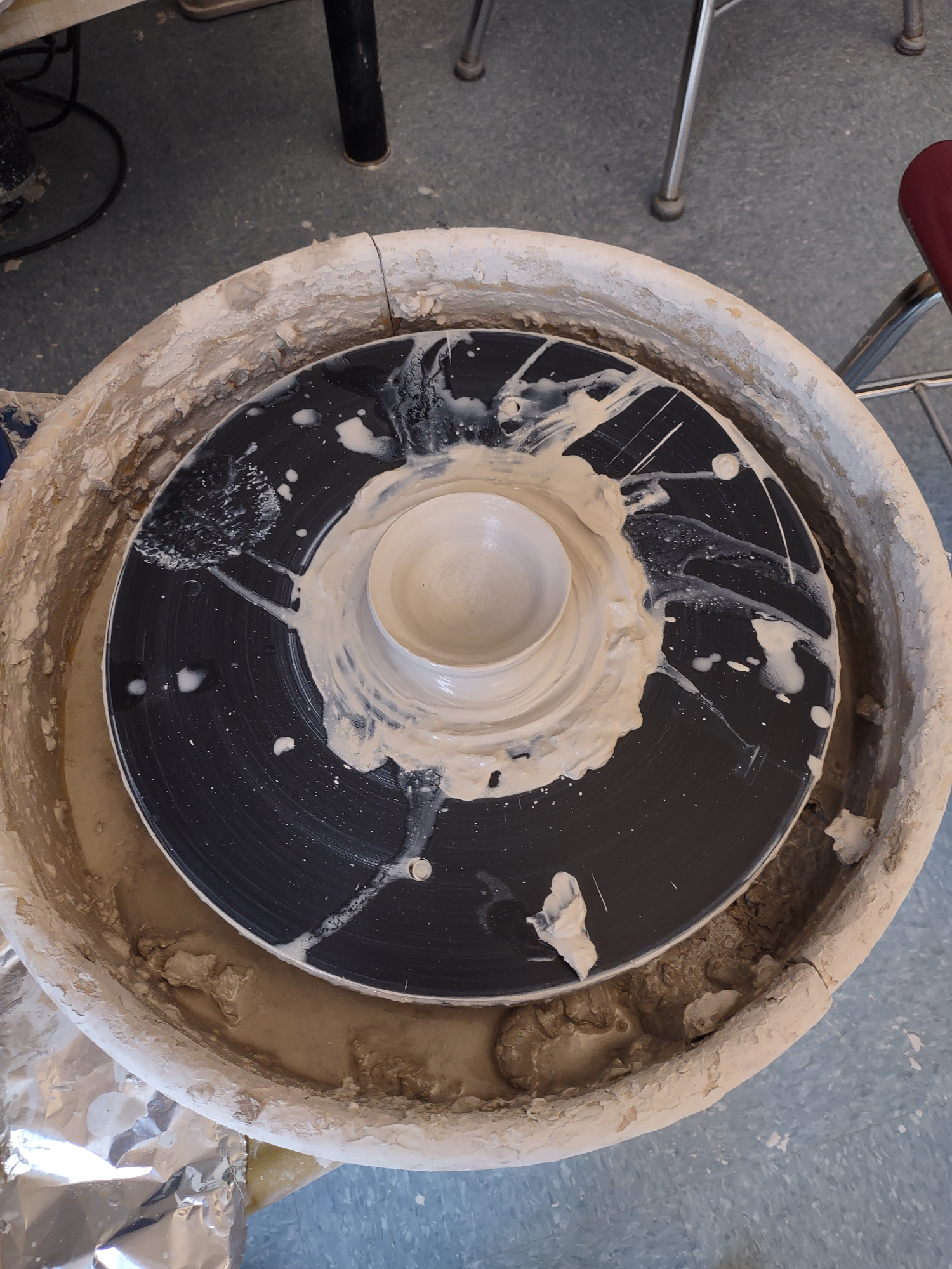 Ceramic bowl on potters wheel seen from above.